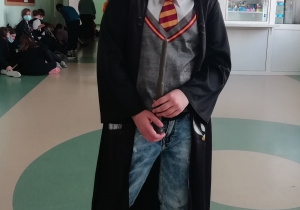 Czyżby Harry Potter miał brata bliźniaka. Chłopiec stoi pośrodku korytarza.